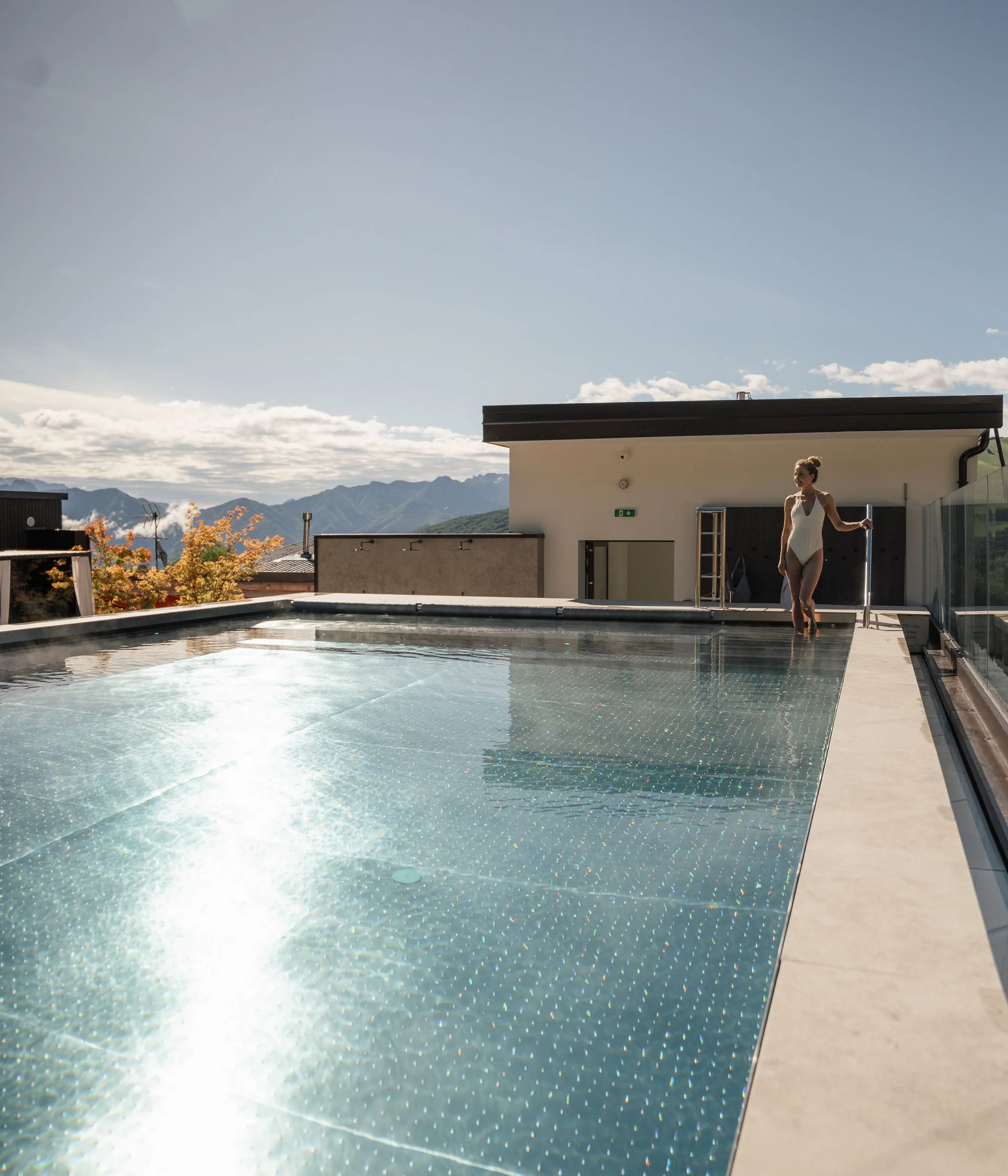 Elgus: hotel a San Giacomo, a Brentonico Donna in costume da bagno vicino a piscina all'aperto con vista sulle montagne