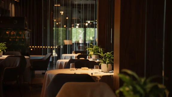 Elgus: hotel a San Giacomo, a Brentonico Interno di un ristorante elegante con tavoli apparecchiati e piante verdi