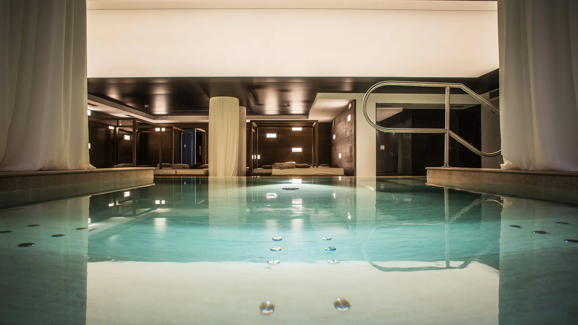 Elgus: hotel a San Giacomo, a Brentonico Piscina interna con acqua limpida e luci soffuse in un ambiente moderno