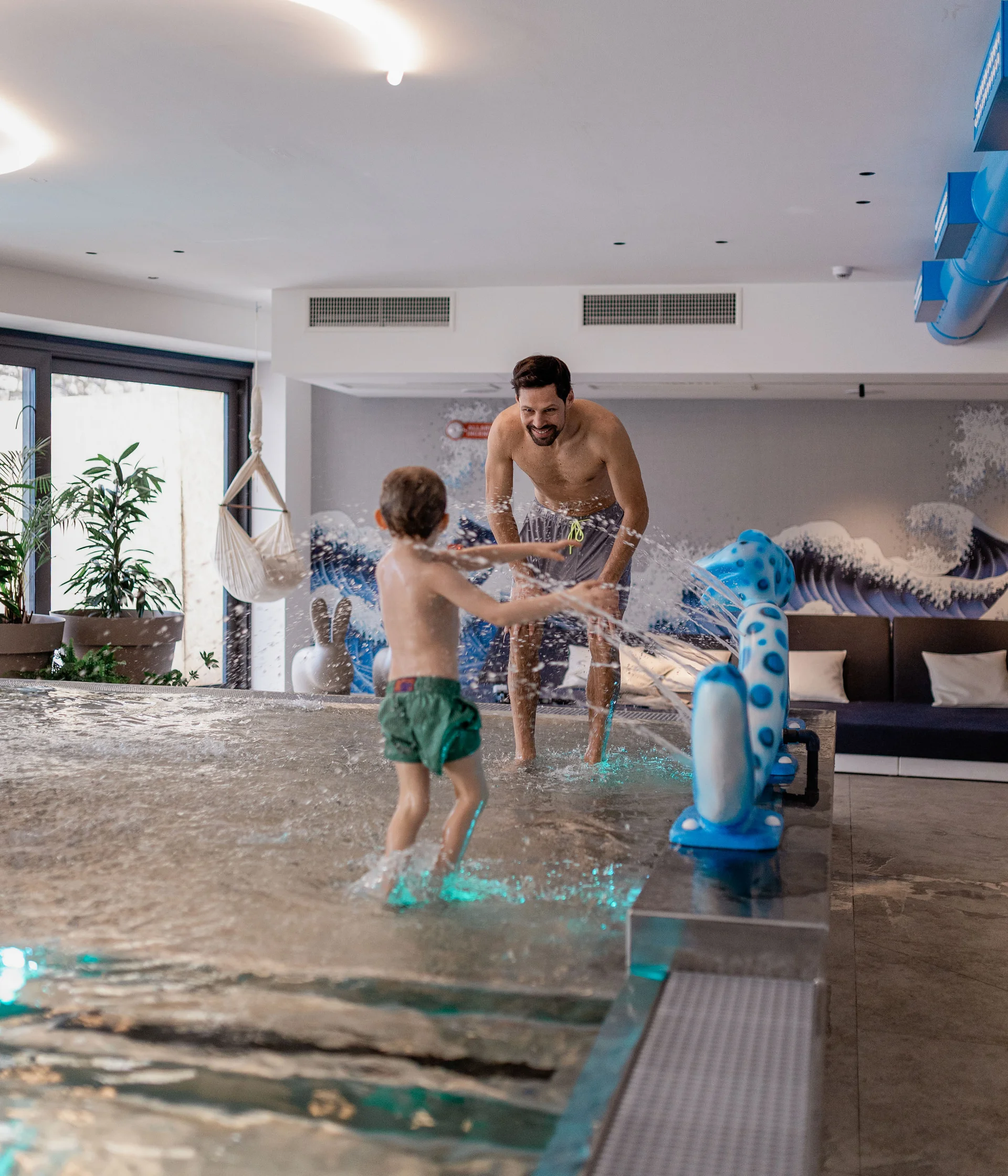 Elgus: hotel a San Giacomo, a Brentonico Bambino e uomo che giocano nell'acqua in piscina interna moderna